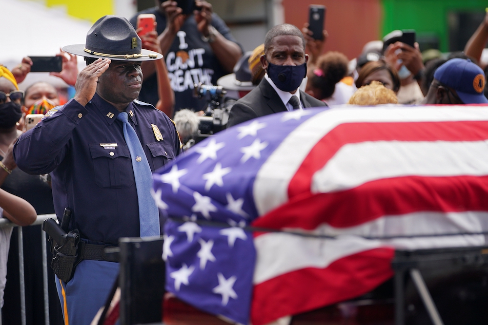 An Alabama State Trooper salutes the casket carrying the late Rep. John Lewis, D-Ga., after it was carried across the Edmund Pettus Bridge in a horse-drawn carriage in Selma, Alabama, July 26. The civil rights movement legend who was a colleague of the Re