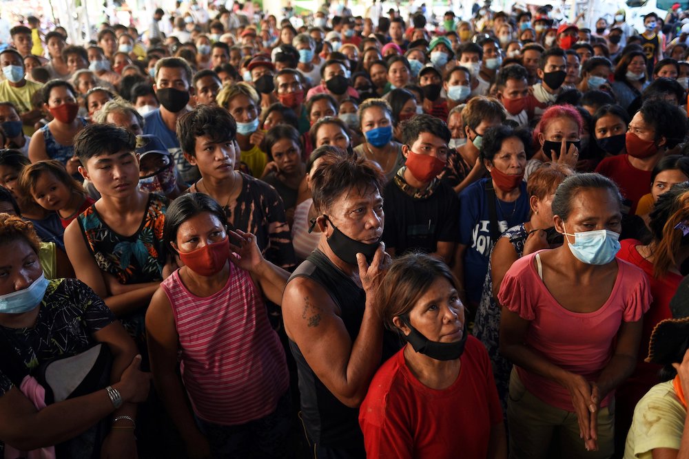 Residents wait for relief goods at an evacuation center in Manila, Philippines, Nov. 13, following Typhoon Vamco. Five tropical storms or typhoons have hit the Philippines in a three-week period, including the strongest typhoon since 2013 and the biggest 