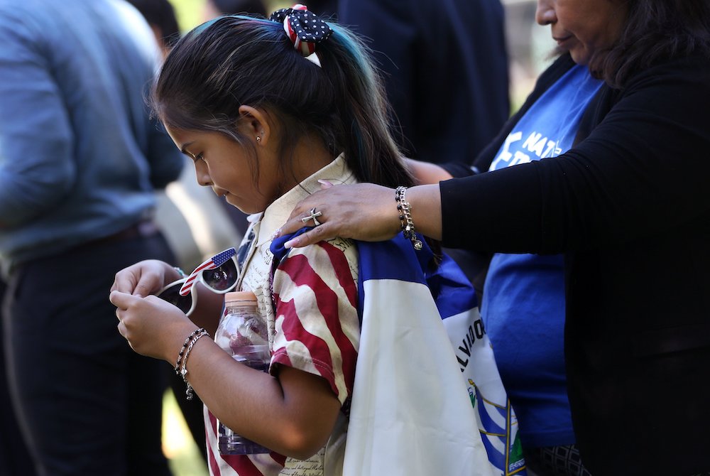 Marilyn Miranda, 9, draped in a Salvadoran flag, attends an immigration rally with her mother outside the U.S. Capitol in Washington June 4, 2019