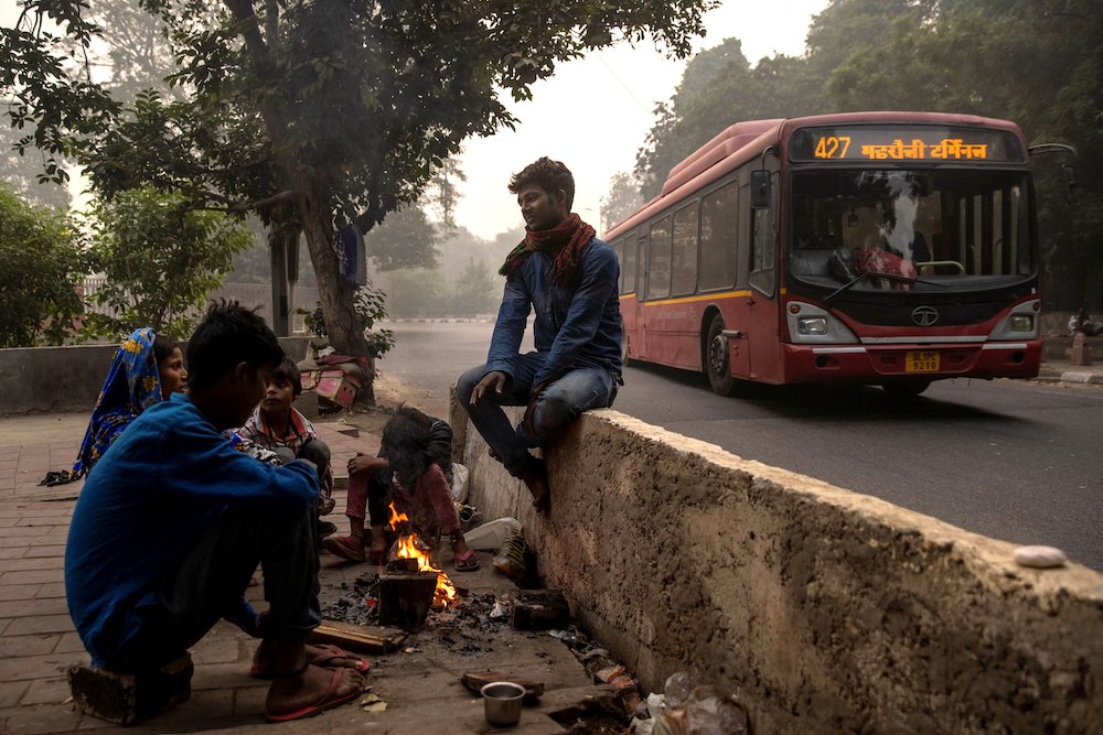 A homeless family warms by a fire along a road in New Delhi, India, on Nov. 9. (CNS/Reuters/Danish Siddiqui)