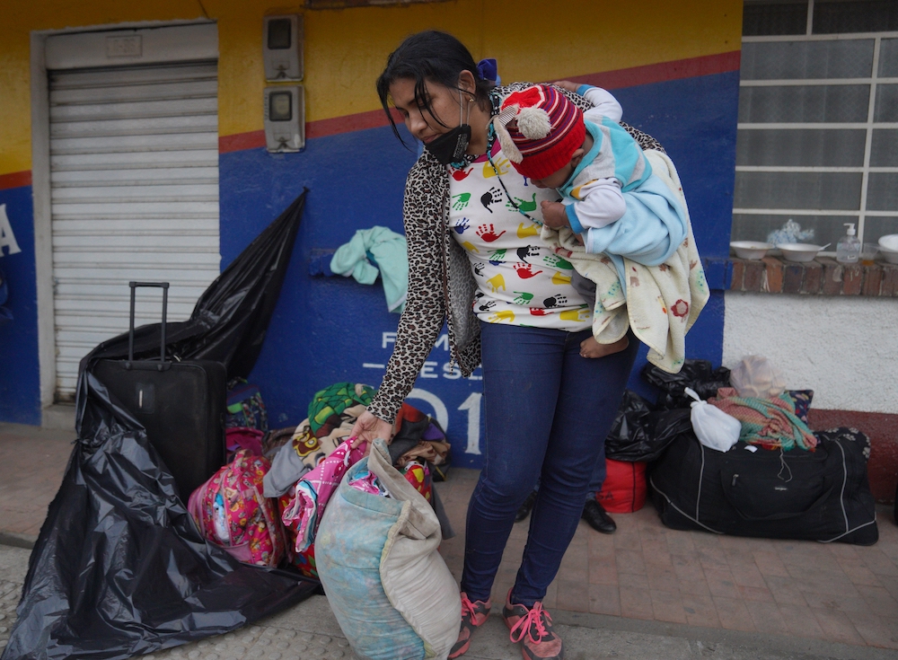 Venezuelan migrant Luisiana Cordoba organizes her belongings as she takes a break in Gachancipa, Colombia, June 28, 2020. Cordoba had been on the road for a week and was trying to make her way to Venezuela with her three children, after losing her job in 