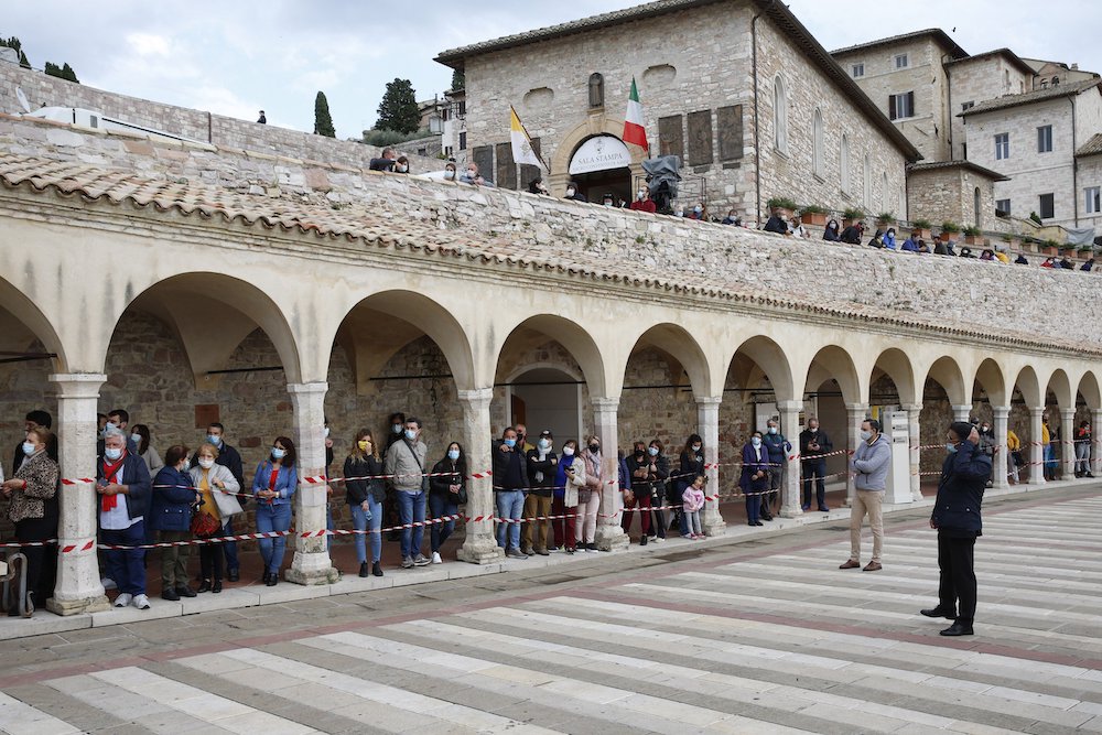 People wait to see Pope Francis outside the Basilica of St. Francis in Assisi, Italy, Oct. 3. The pope celebrated Mass and signed his new encyclical, " 'Fratelli Tutti,' on Fraternity and Social Friendship," in the crypt of the basilica. (CNS/Paul Haring) People wait to see Pope Francis outside the Basilica of St. Francis in Assisi, Italy, Oct. 3. The pope celebrated Mass and signed his new encyclical, " 'Fratelli Tutti,' on Fraternity and Social Friendship," in the crypt of the basilica. (CNS/Paul Haring)