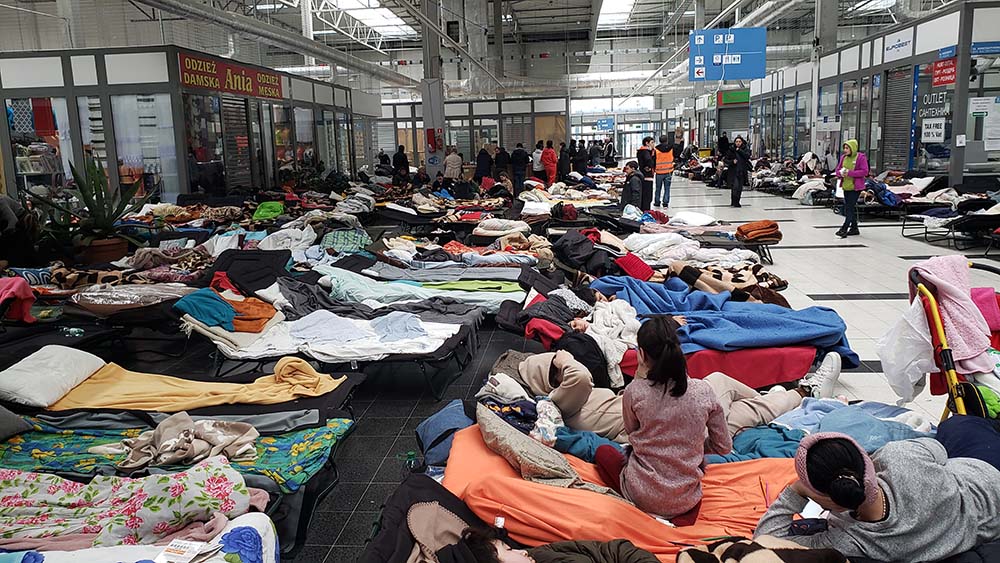 Refugees sleep on cots in open spaces at a refugee transit center at a shuttered shopping complex in Korczowa, Poland. (GSR photo/Chris Herlinger)