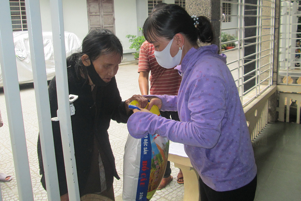 COVID-19 food aid in Thua Thie Hue province A Catholic volunteer gives aid to the mother of a pregnant woman Sept. 5 in the Huong Tra district of Thua Thie Hue province. (Peter Nguyen)