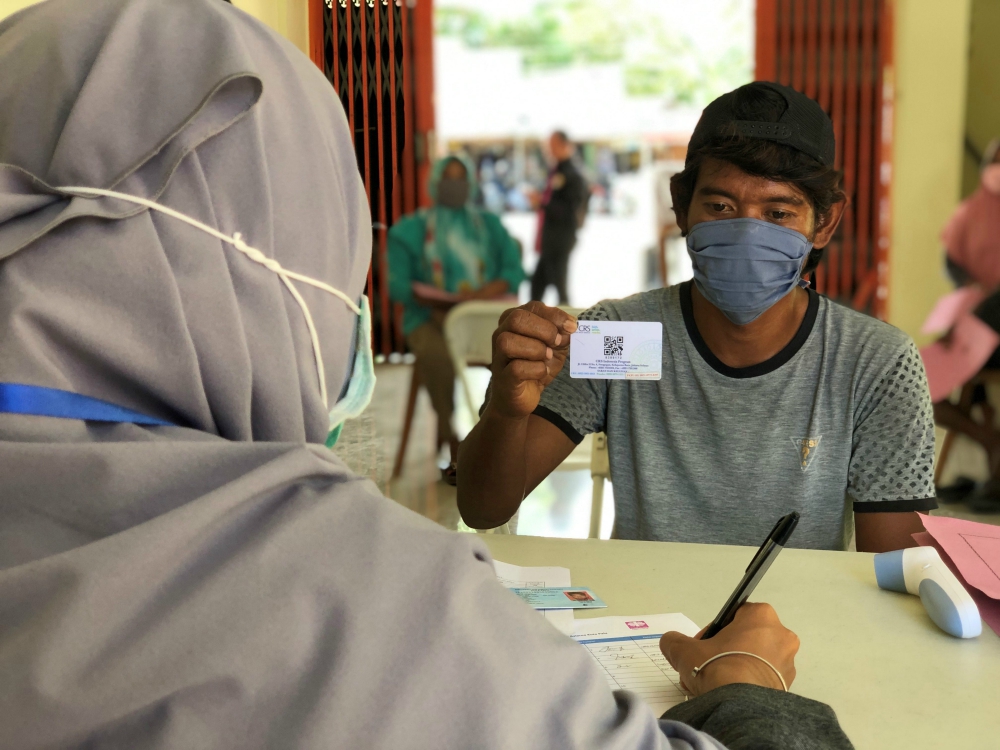 Catholic Relief Services' money distribution in Palu, Indonesia, to families needing cash to retrofit houses damaged in a 2018 tsunami continues despite the coronavirus pandemic. (Courtesy of Catholic Relief Services / Prillimala Angelisca)