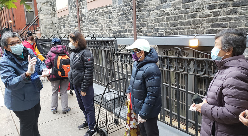 Sr. Yolanda Flores, left, talks to people in line for Cabrini Immigrant Services' weekly food pantry in Manhattan's Lower East Side on Oct. 27. (GSR photo/Chris Herlinger)