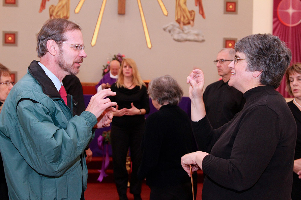 Sr. Conchetta LoPresti signs with a member of her congregation after a 2013 Mass. (Courtesy of Sisters of St. Francis of the Neumann Communities)