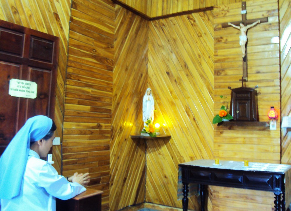 A Daughter of Mary of the Immaculate Conception prays privately March 30 for the end of the coronavirus at the chapel of the community's motherhouse in Hue City. (Joachim Pham)