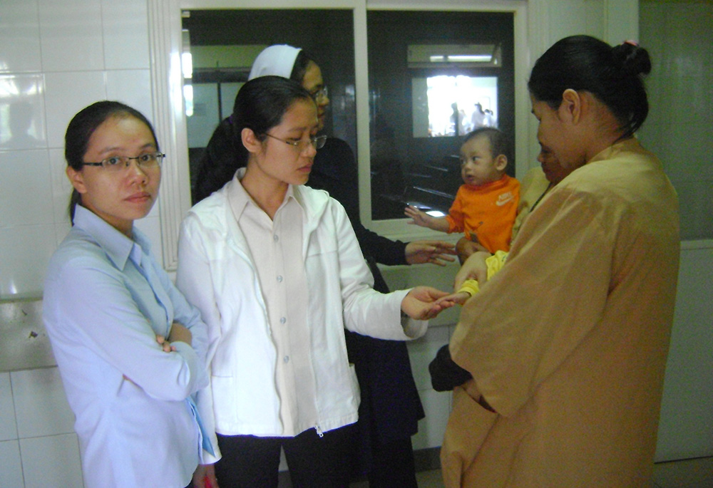 Three Daughters of Our Lady of the Visitation visit with two mothers and their babies Dec. 27, 2021, at a hospital in Hue, Vietnam. (Joachim Pham)