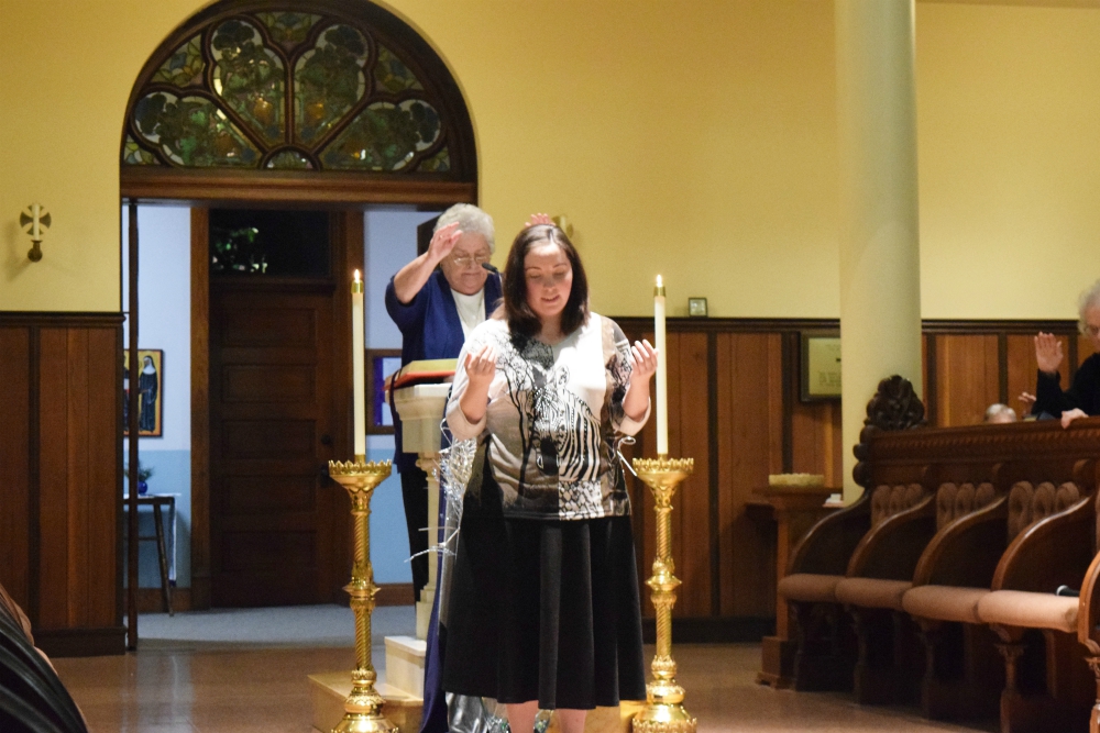 Sr. Esther Fangman, prioress of the Benedictine Sisters of Mount St. Scholastica of Atchison, Kansas, blesses Emily Bauer, 26, as she makes her vows as a canonical novice with the community Dec. 7, 2019.