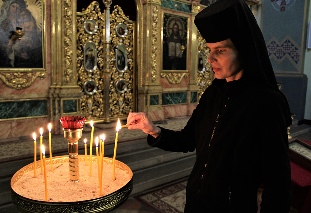 La Hna. Evphrosynia Senyk, que forma parte de la Congregación de las Hermanas de San José de la Iglesia católica ucraniana, enciende una vela en el santuario de la parroquia greco-católica de la Exaltación de la Santa Cruz, antigua iglesia de San Norberto, en Cracovia (Polonia). La iglesia ucraniana se ha convertido en un refugio para los ucranianos que huyen de la guerra en Ucrania. (Foto: GSR/Chris Herlinger)