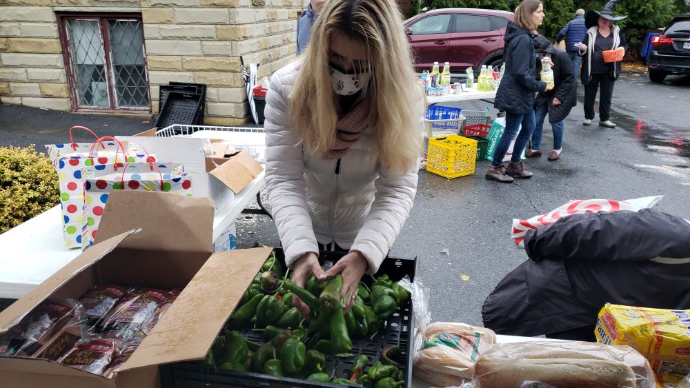 A volunteer prepares donated vegetables by Harmony Farm for weekend food distribution at the First Presbyterian Church in Goshen, N.Y. (Chris Herlinger)