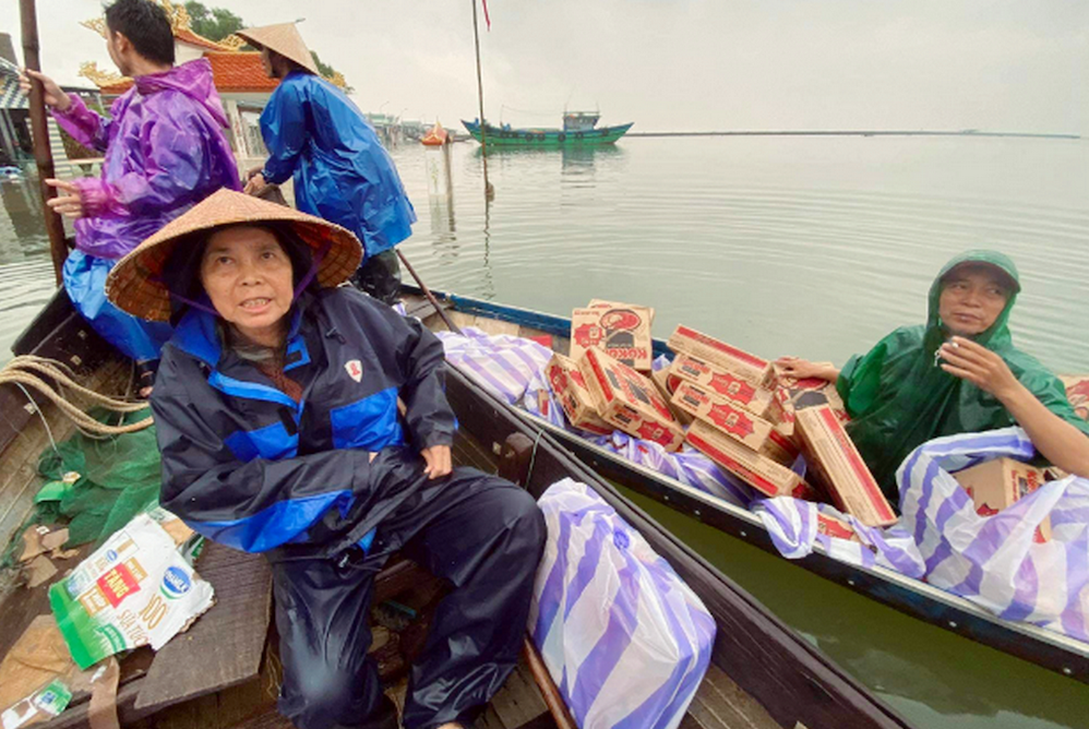 Lovers of the Holy Cross Sr. Mary Tran Thi Nhuong and volunteers carry instant noodles on boats to save flood victims in Quang Dien District. (Joachim Pham)