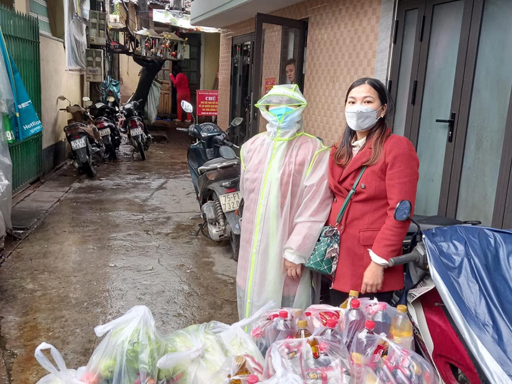 Two Catholic volunteers provide food to COVID-19 patients quarantined in their homes in Hue, Vietnam, on March 5. (Joachim Pham)