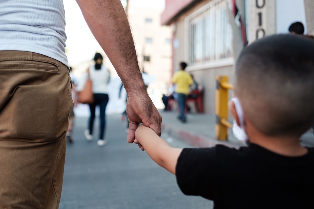 A father and son take part in the Oct. 21 Children Seeking Asylum March at the U.S.-Mexico border, in which children asylum-seekers, their families and immigration advocates protested the dismantling of the asylum system and the consequences on children. 