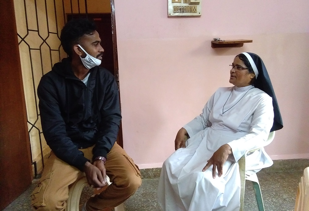 Anand Patil, who grew up in Asha Sadan in Baina, Goa, western India, talks with Sr. Lourenca Marques of the Congregation of the Sisters of Holy Family of Nazareth. (Lissy Maruthanakuzhy)