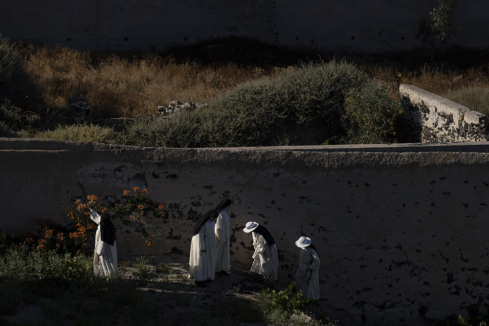 Cloistered nuns walk in the garden of the Catholic Monastery of St. Catherine on the Greek island of Santorini on June 15. When not praying in church or practicing sacred music and hymns, the nuns tend to the garden, where they grow fruits and vegetables.