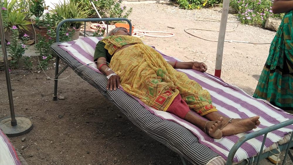 An elderly nun who has tested positive for COVID-19 lies on a cot in the shade outside Jyoti clinic in Chachana village, Gujarat, India. (Courtesy of Chetan Parmar) An elderly nun who has tested positive for COVID-19 lies on a cot in the shade outside Jyoti clinic in Chachana village, Gujarat, India. (Courtesy of Chetan Parmar)