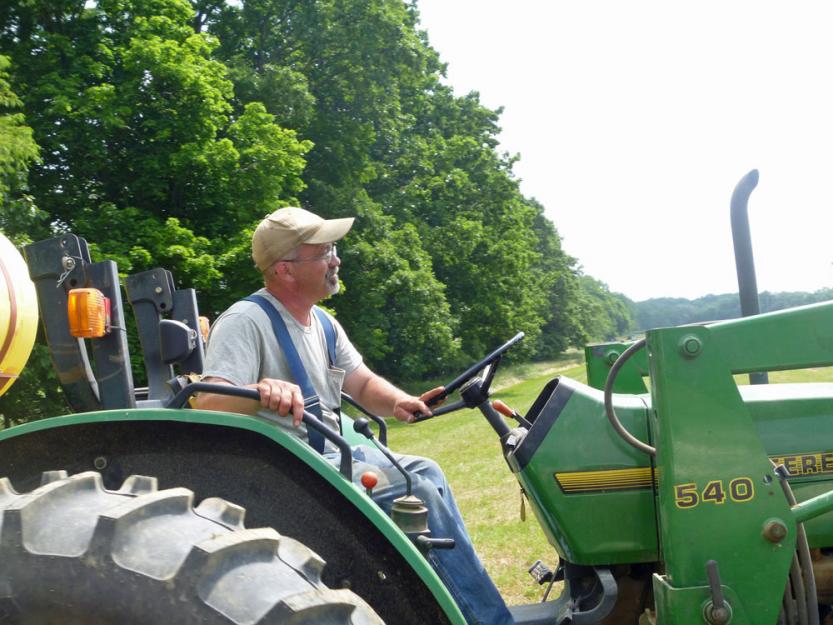 John Moreira, director of land management at Villa Maria Farm, takes the tractor out to one of the farm's many fields.