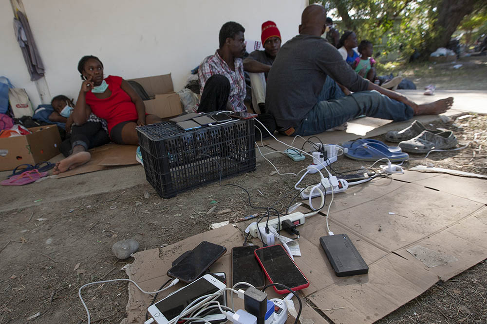Haitians charge their cellphones Sept. 22 at an immigration camp in Ciudad Acuña, Mexico. Some in this group decided to stay in Mexico for fear of being deported back to Haiti if they tried to cross into the U.S. (Nuri Vallbona)