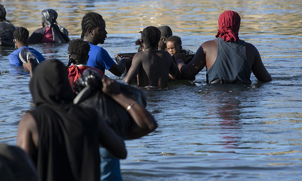 A child floats across the Rio Grande in a container to keep him safe with other Haitians wading from Ciudad Acuña, Mexico, to Del Rio, Texas, Sept. 22. (Nuri Vallbona)