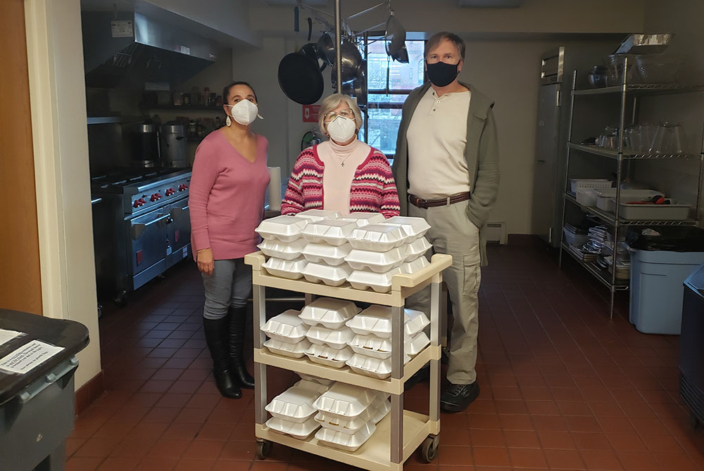 At the Franciscan Center for Urban Ministry in Hartford, Connecticut, Mercy Sr. Beth Fischer (center) serves meals Dec. 10 with volunteers Lilly Velez Herrera and Fr. Mike Johnson. (Provided photo)