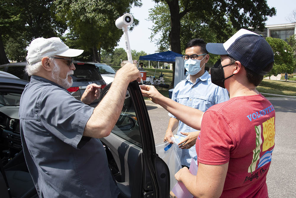 Fengpeng Sun, center, a climate scientist at the University of Missouri-Kansas City, assists volunteers as they secure a heat-monitoring sensor to their vehicle Aug. 6 as part of a campaign by the NOAA to map disparities in heat.