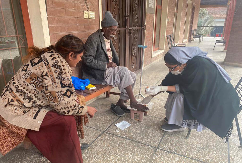 A Sister of Charity of Jesus and Mary attends to the wounds of a man at Shakina Home for the Aged in Youhanabad, Lahore, Pakistan. (Courtesy of Sabina Barkat)