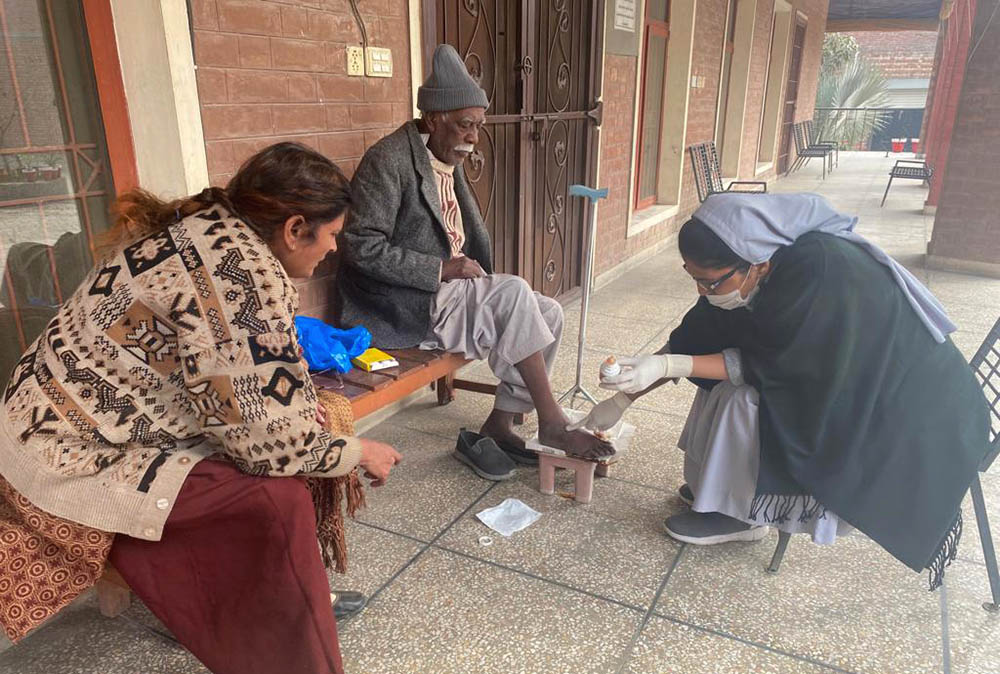 A Sister of Charity of Jesus and Mary attends to the wounds of a man at Shakina Home for the Aged in Youhanabad, Lahore, Pakistan. (Courtesy of Sabina Barkat)