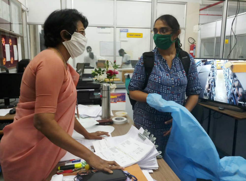 Sr. Jessie Saldanha, left, of the Sisters of Charity of Nazareth meets with an employee at St. John's National Academy of Health Sciences in Bangalore, India. She is head of the institution's pharmacy department.