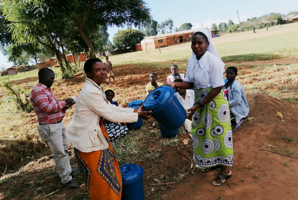 Sr. Teresa Mulenga distributes tap buckets for use by five HIV/AIDS support groups in Dedza, a town in the central region of Malawi, in the fight against the COVID-19 pandemic. (Provided photo)