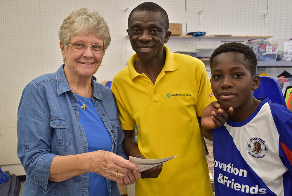 Notre Dame de Namur Sr. Mary Alice McCabe welcomes an Angolan father and son to the Humanitarian Respite Center in McAllen, Texas, in January 2020. (Courtesy of Mary Alice McCabe)