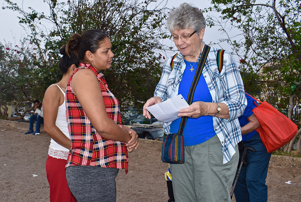 Notre Dame de Namur Sr. Mary Alice McCabe, right, welcomes a recently arrived Honduran mother to a migrant camp in Matamoros, Mexico, in 2019. (Courtesy of Mary Alice McCabe)