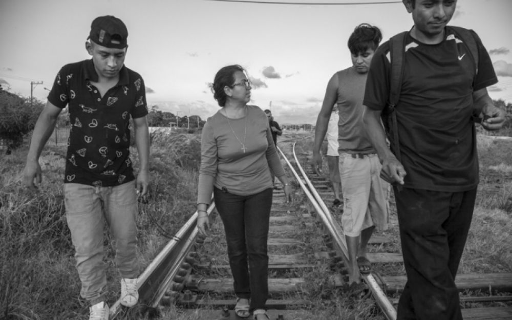 La hermana del Ángel de la Guarda Eligia Ayala Molina, en el centro, camina con los migrantes alrededor de las vías del tren vecino. 