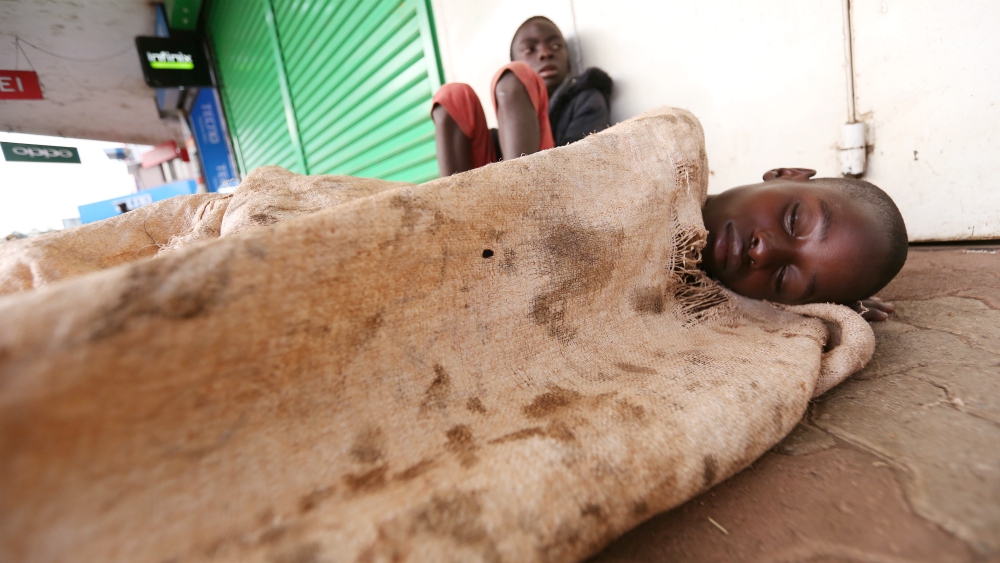 A street child sleeps on a sidewalk in Nairobi, Kenya. There are many socioeconomic factors in families that contribute to the increase of street children in Kenya. (Doreen Ajiambo)