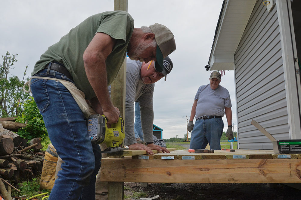 From left: Jude Leake, Ed Mattingly and Rick Wagoner build a new porch on a home May 23, more than six months after an EF4 tornado badly damaged the home in Mayfield, Kentucky. (GSR photo/Dan Stockman)