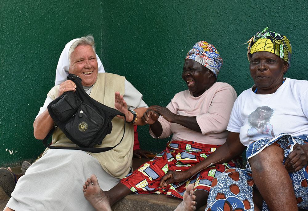 Sr. Judith Bozek, a Missionary Sister of the Holy Family, shares a light moment with Esnart Kangwa (in pink shirt), one of the elderly residents at the Cheshire Divine Providence Home, located in a large slum just southwest of Lusaka, Zambia.