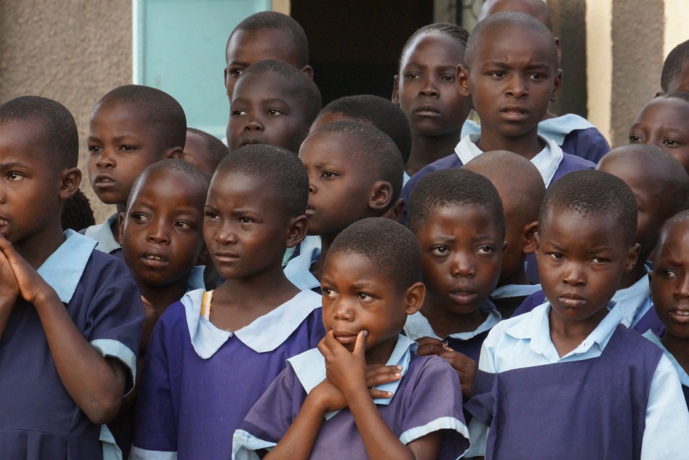 Kenyan schoolchildren listen to their teacher in June 2019 outside their classroom in Bungoma in western Kenya. According to UNESCO, the education of 1.54 billion pupils in 185 countries has been curtailed during the pandemic. (Doreen Ajiambo)