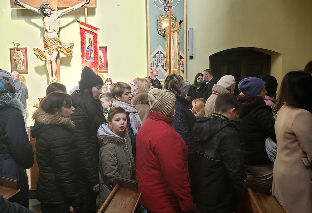 Feligreses a la salida de una misa dominical el 13 de marzo de 2022 en la parroquia greco-católica de la Exaltación de la Santa Cruz en Cracovia, Polonia. La iglesia se ha convertido no solo en un lugar de culto, sino también en uno al que acuden las personas que huyen de la guerra en Ucrania para recibir noticias y contactos, y recoger alimentos y ropa donados. (Foto: GSR/Chris Herlinger)