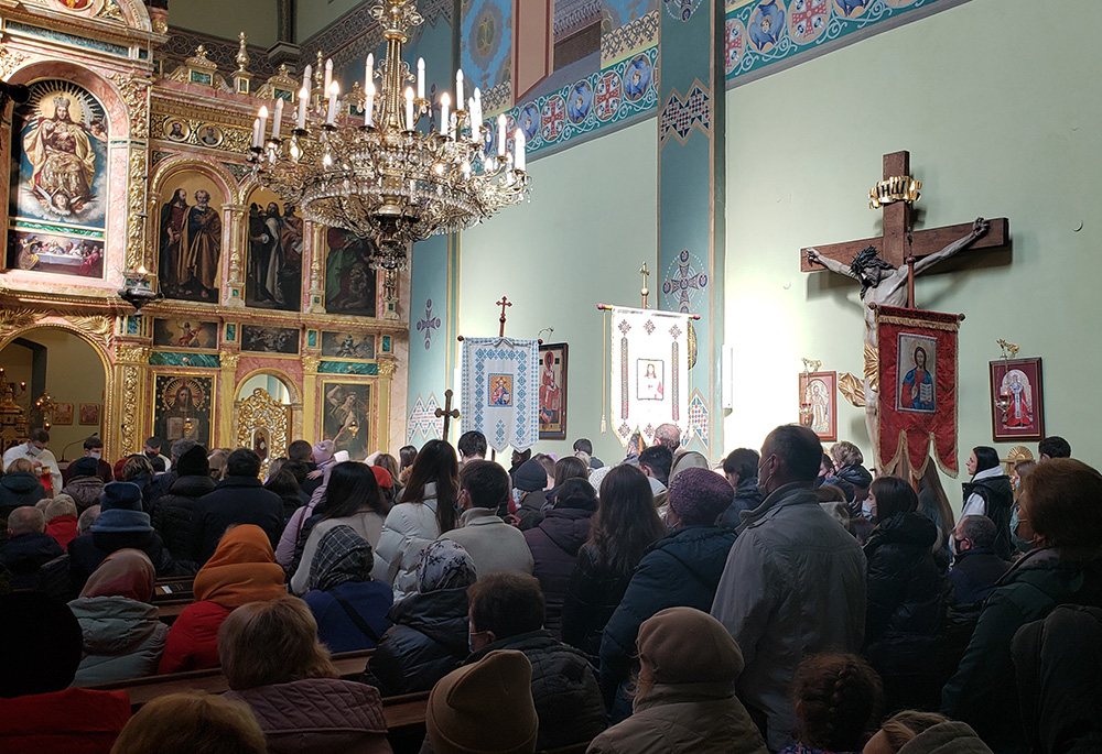 Un grupo de personas permanece de pie en los pasillos de la parroquia greco-católica de la Exaltación de la Santa Cruz en Cracovia, Polonia, durante un oficio religioso el 13 de marzo. El número de asistentes a los oficios ha aumentado mucho en las semanas transcurridas desde que comenzó la guerra en Ucrania el 24 de febrero de 2022, aseveró el padre Peter Pawliszcse. (Foto: GSR/Chris Herlinger)