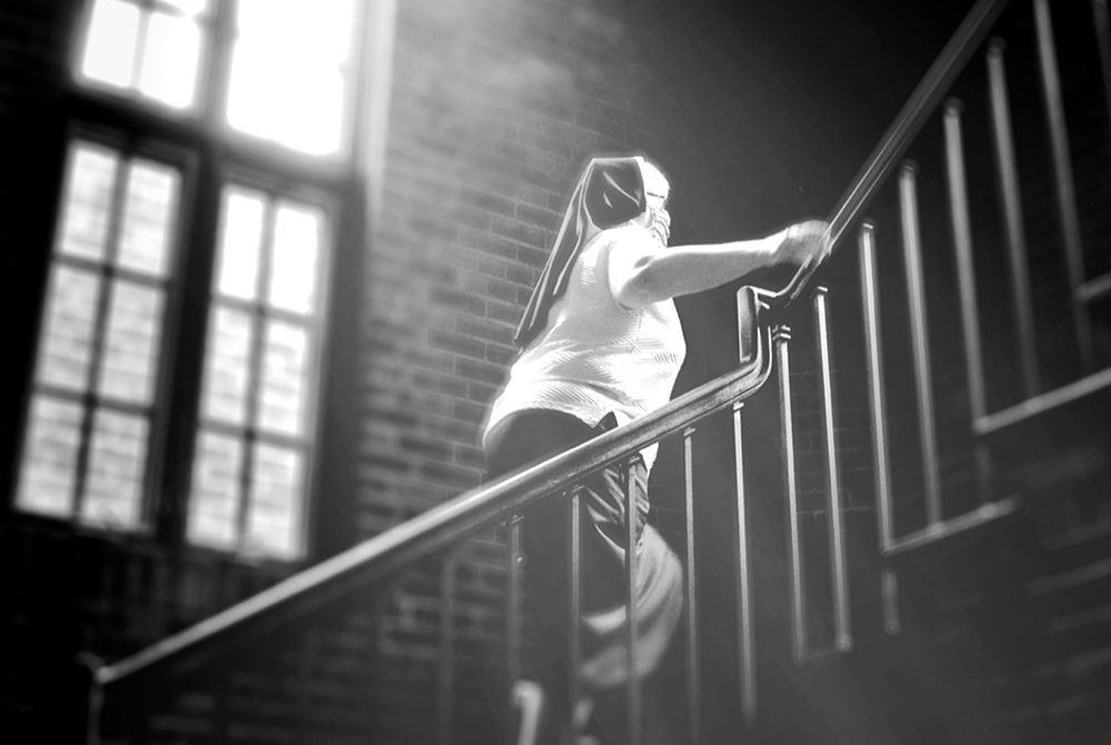 Felician Sr. Mary Ann Smith climbs a staircase in the Felician Sisters' convent in Livonia, Michigan, in June 2020 in this photo illustration. (GSR illustration/Dan Stockman)