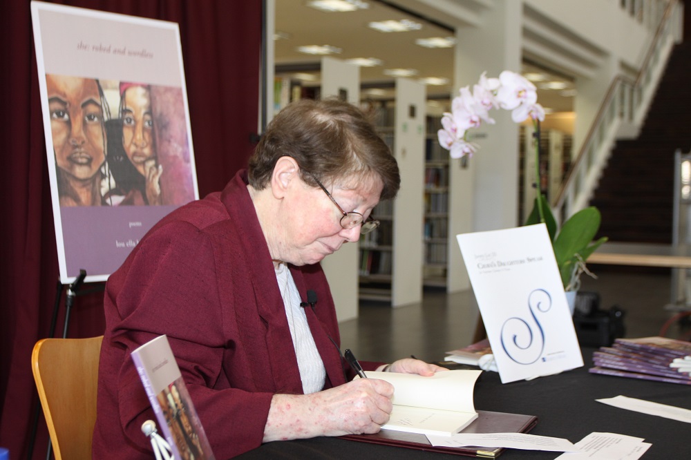 Sr. Lou Ella Hickman signs a copy of her book, she: robed and wordless, at La Retama Central Library in Corpus Christi, Texas, during a presentation May 1. (Courtesy of the Sisters of the Incarnate Word and Blessed Sacrament)