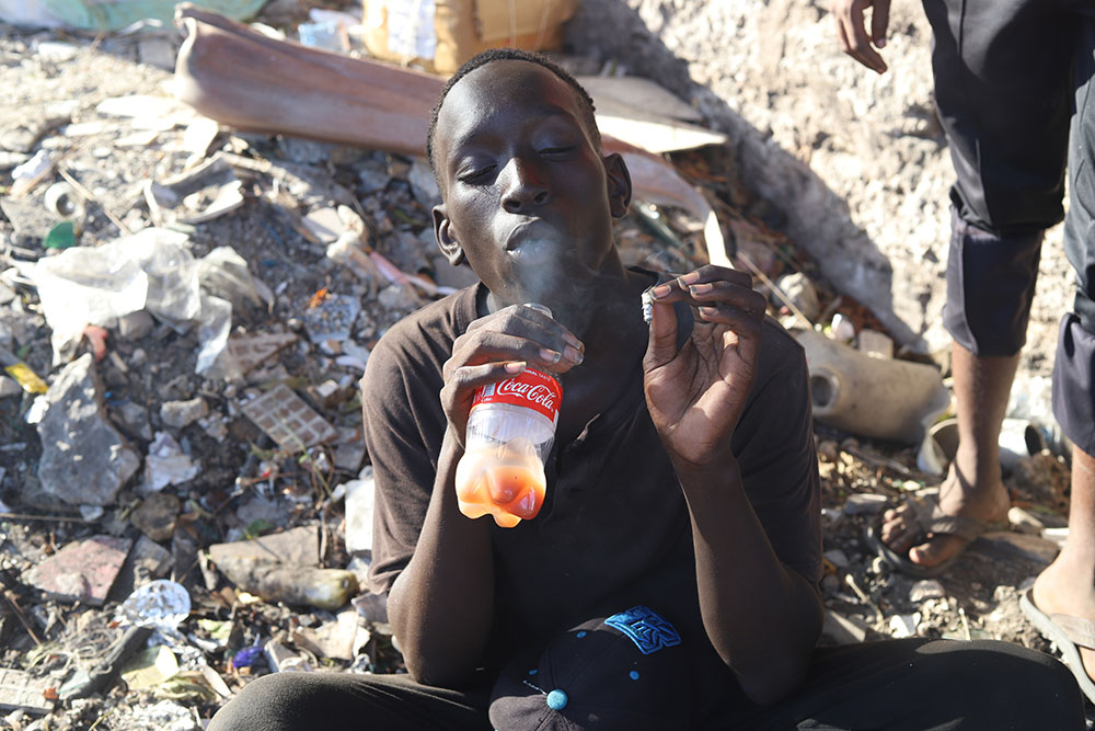 A youth sniffs toxic glue and smokes marijuana on the streets of Mombasa, Kenya. (GSR photo/Doreen Ajiambo)