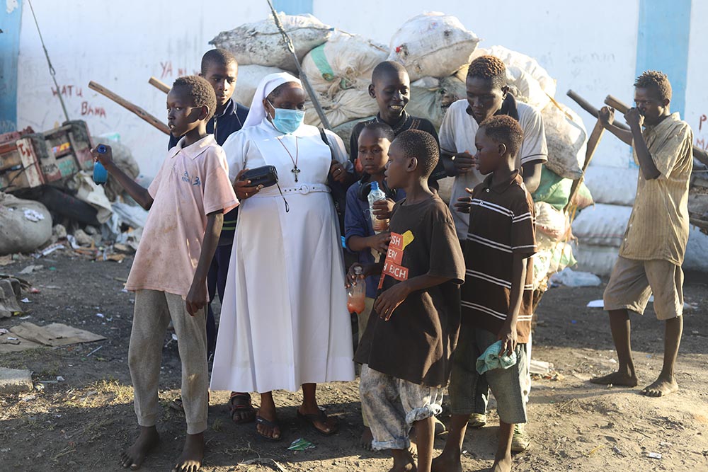 Sr. Jane Frances Kamanthe Malika puts on music from her radio to entertain children from the streets and encourage them to come to the Grandsons of Abraham Rescue Centre.