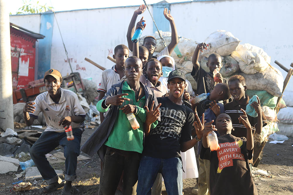 Children and youths from the streets enjoy the music from a radio that has been given to them by St. Joseph Sr. Jane Frances Kamanthe Malika. (GSR photo/Doreen Ajiambo)