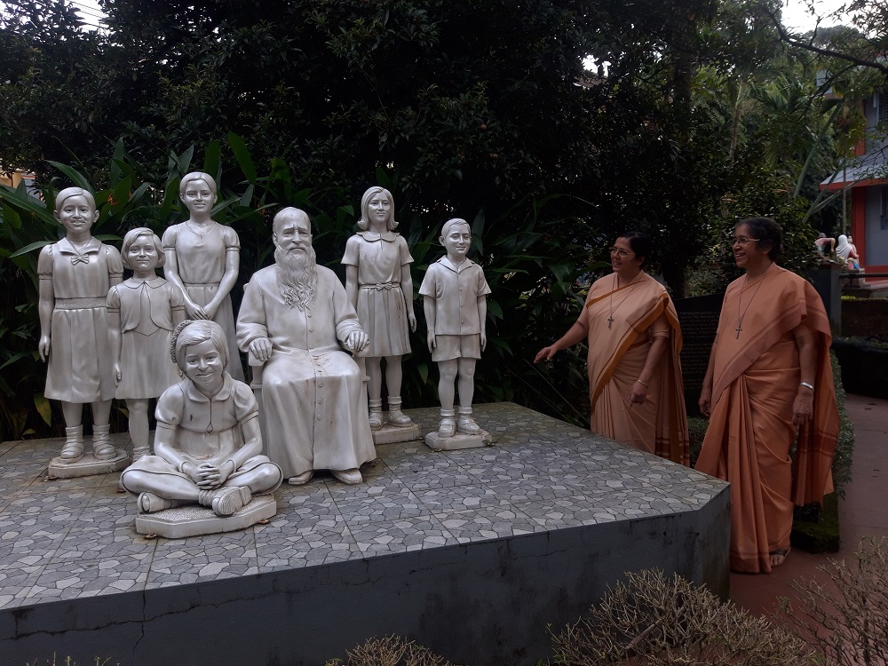 Sr. Mariette Crasta, the coordinator of the Bethany Champions, left, with her superior general, Sr. Rose Celine Fernandes, near the sculptures of their founder and boarding school girls who later became Bethany Sisters. (Thomas Scaria)