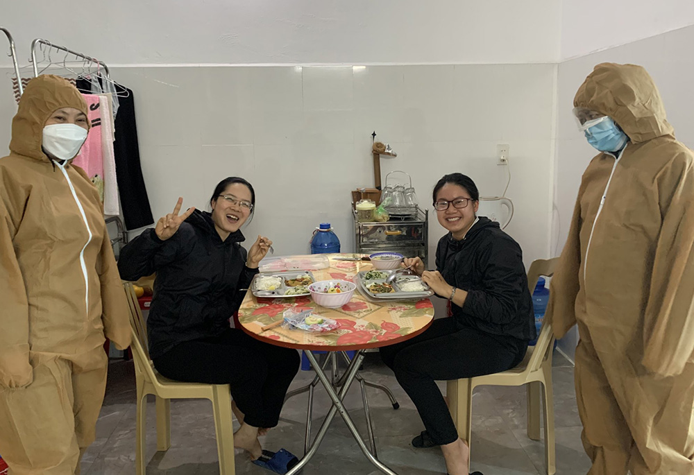Sr. Mary John Théophan Vénard Doan Thi Chuyen, far left, and another sister in medical gear serve a meal to two nuns with COVID-19 at Ho Ngoc Can Clinic in Xuan Truong district, Nam Dinh province. (Daughters of Our Lady of the Holy Rosary of Bui Chu) Sr. Mary John Théophan Vénard Doan Thi Chuyen, far left, and another sister in medical gear serve a meal to two nuns with COVID-19 at Ho Ngoc Can Clinic in Xuan Truong district, Nam Dinh province. (Daughters of Our Lady of the Holy Rosary of Bui Chu)