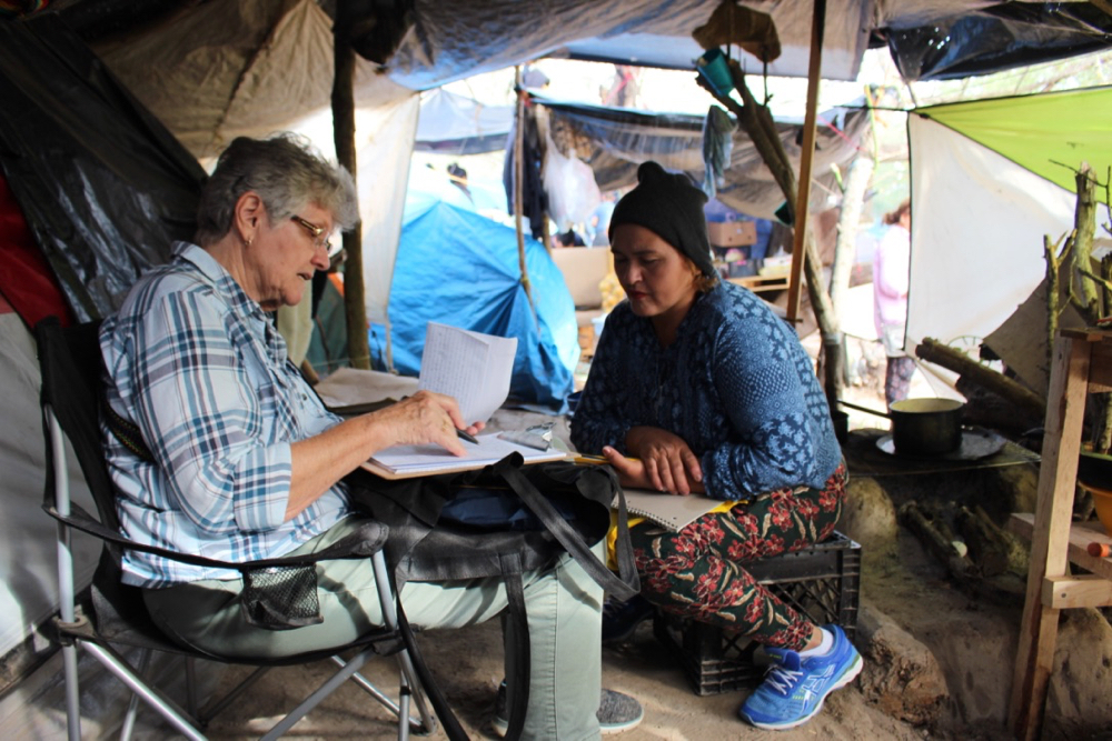 Sr. Mary Alice McCabe usually takes several days to work with each asylum seeker on their legal cases, usually from within their own tents, or under the tarpaulins where they have set up their kitchens. (GSR photo / Tracy L. Barnett)