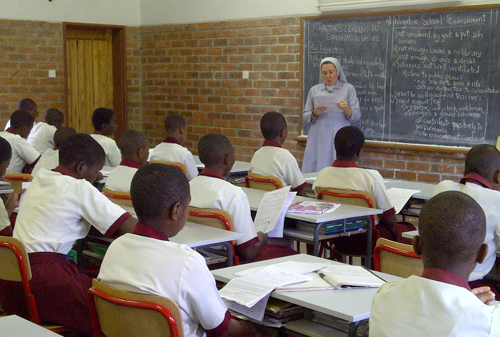 Estudiantes en un salón de clases escuchan a la hermana Dwyer. 