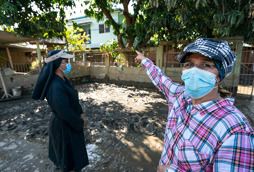 Srs. Milena Vanegas, left, and Victoria Emérita in the mud-covered playground of the nursery school they operate in La Planeta, a neighborhood of La Lima, Honduras, in late January.